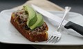Open-faced grilled cheese with refried beans, caramelized onions and avocado on cornbread