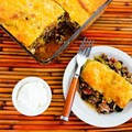 Spicy green chile Mexican casserole with ground beef, black beans, and tomatoes